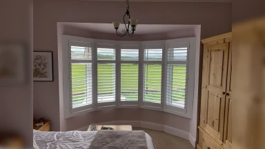 Bay window shutters showing grass area outside
