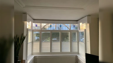 Cafe style shutters on a detailed window