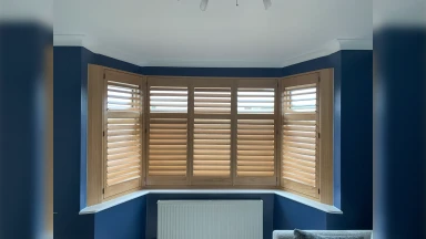 Light wood bay window shutter in Rotherham with blue walls