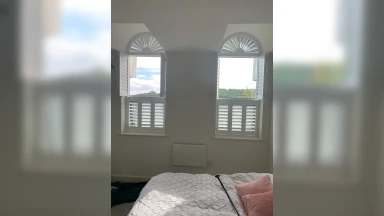 Two symmetrical tier on tier window shutters with rounded top