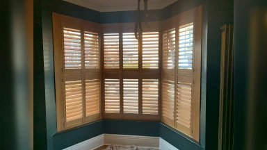 Wooden tier on tier window shutters in bay window