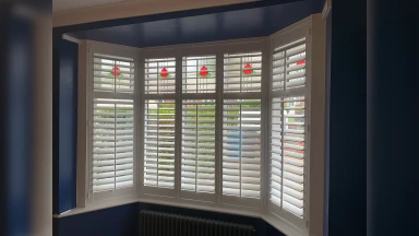 Stained glass window with bay window shutter covering