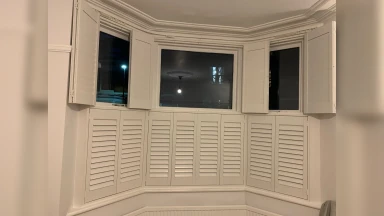 Tier on tier window shutters half open at night in Sheffield
