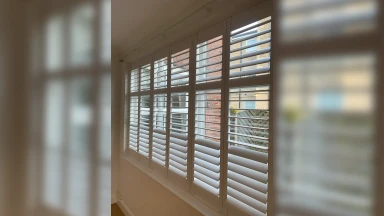 Full height shutters across a wide living room window