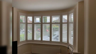 Open window shutters fitted into a bay window