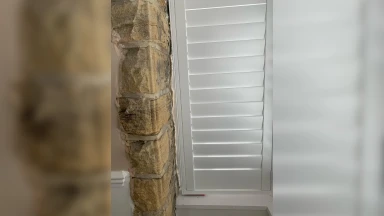 Closed window shutter that is well fitted against an even stone wall