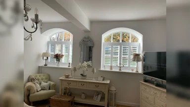 2 symmetrical shaped cafe style windows in a bedroom